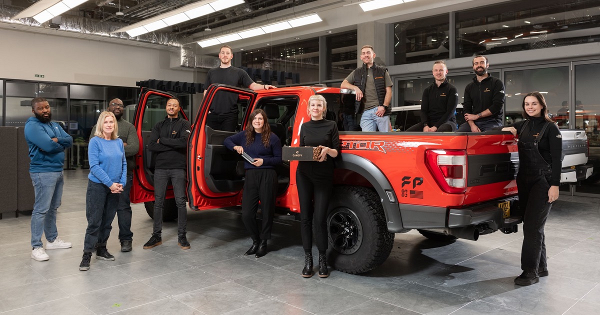 Canopy's full UK team poses by a truck in their workshop.