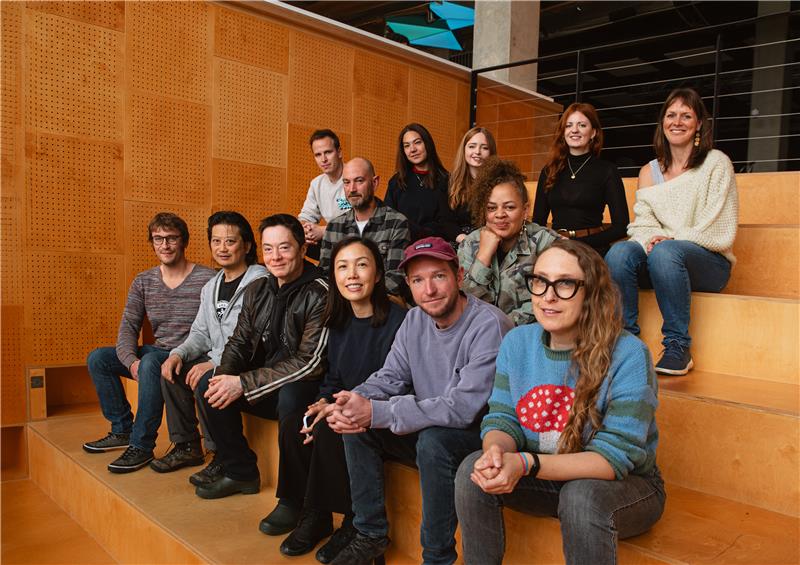 Group photo of a dozen or so individuals sitting in wooden bleachers